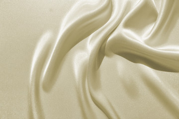 Delicate satin draped fabric beige texture for a celebratory backgrounds