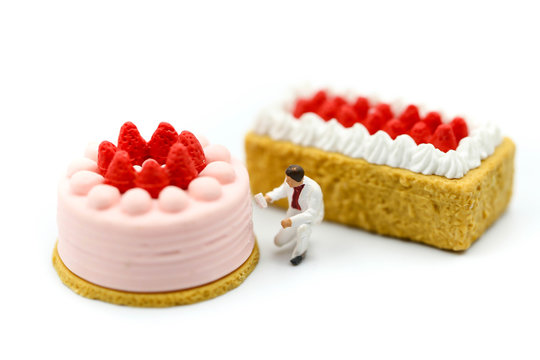 Miniature people : Worker painting with Sweet dessert,cooking and decoration concept.