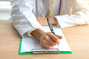 Close-up of a female doctor sitting on a note