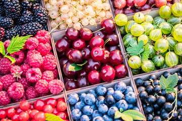 Different colorful berries in wooden box. Close-up.