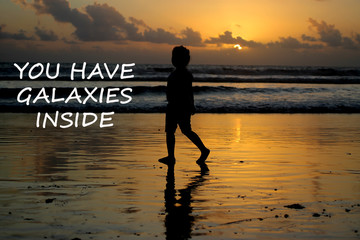 Children inspirational words - you have galaxies inside. Silhouette of a girl at sunset.  Kid...