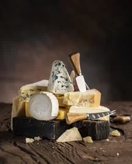 Fotobehang Assortment of different cheese types on wooden background. Cheese background. © volff
