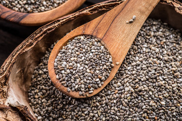 Chia seeds in organic dish on old wooden table. Top view.