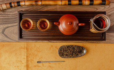 tea table with instruments teapots cups pancake and tea Shen Puer