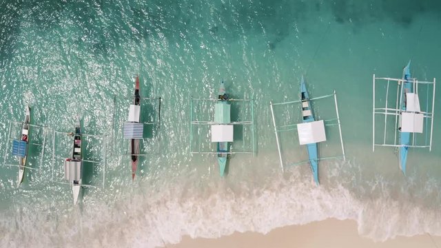 4K Aerial Drone footage of many boats on a tropical beach in the philippines. Guyam Siargao top down