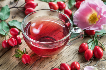 Rose-hips and rose hip seed oil on the wooden table.