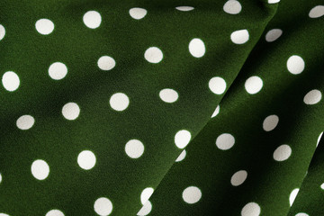 Green and white polka dot textile close up. Abstract background