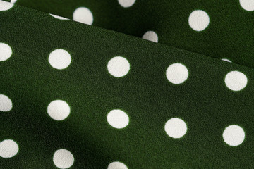 Green and white polka dot textile close up. Abstract background