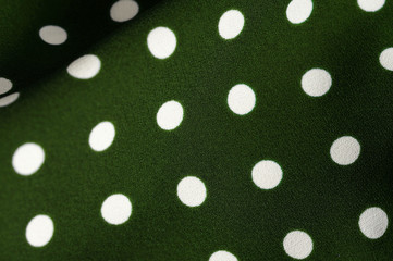 Green and white polka dot textile close up. Abstract background