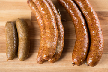 Regionale norddeutsche Grünkohl Kohlwurst Variation aus Bremer, Oldenburger und Ammerländer Pinkel auf  Holzbrett auf Marmor Tisch