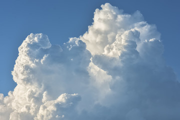 Naklejka na ściany i meble Fluffy white clouds in a blue sky on a sunny day.