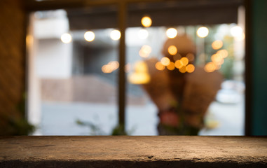 Empty wood table top on blur light gold bokeh of cafe restaurant in dark background