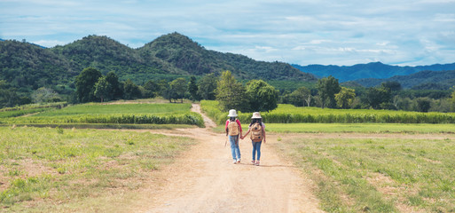Fototapeta premium two asian little girl with backpack walking at natural park outdoor
