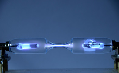 The inert gas Xenon (Xe) seen in a discharge tube emits light due to an electric field.