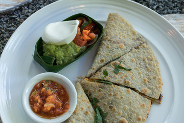 Vegan tortilla wrap, with vegetabes on a wooden background