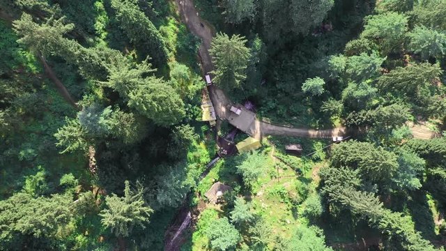 Aerial footage of jana waterfall near manali , himachal pradesh . Going above trees