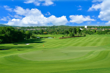 Obraz premium A beautiful view green golf course big tree ,sand bunker and blue cloud sky background.