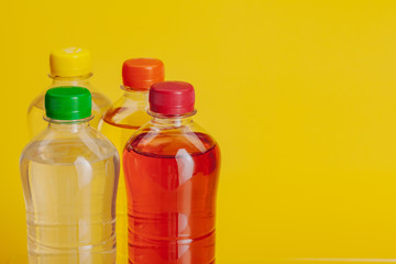Plastic bottle full of drink on a bright yellow background