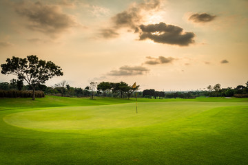 A view landscape green grass at golf course , big trees with black cloud  sunlight rays sky background.