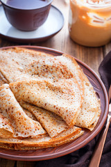 Openwork pancakes on a clay plate, selective focus