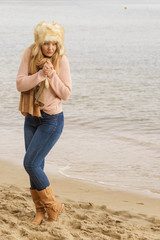 Woman in stylish outfit feeling cold by the sea