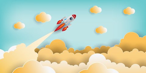 Paper art style of rocket flying over the sky while flying above a cloud. business finance success
