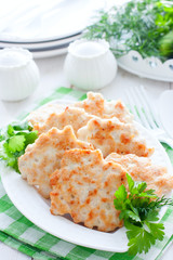 Chopped cutlets of turkey fillet with fresh herbs on a white plate, selective focus