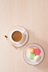 Obraz na płótnie Canvas Cup of coffee with macaroons on wooden background