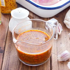 Honey mustard marinade in a transparent glass on a wooden table, selective focus