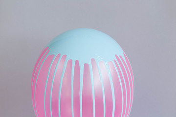 Pink balloon with blue dripping paint on grey background copy space