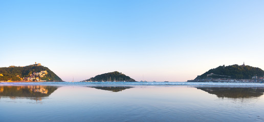 Beach and bay of La Concha with Santa Clara Island and the Igueldo and Urgull mountains in the background in the city of Donostia