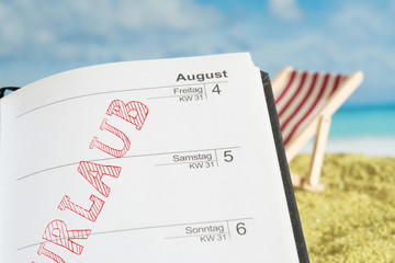 Strand und Kalender mit dem Hinweis auf den Urlaub