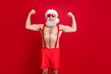 Fototapeta na wymiar Portrait of nice attractive content cheerful funky glad content strong powerful cool gray-haired strong man trainer instructor bodybuilder showing muscles isolated on bright vivid shine red background
