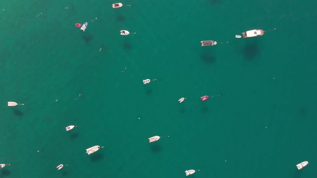 a professional top down aerial shot, over boats at the calm and clear blue adriatic sea