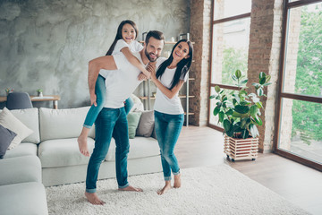 Full length body size view of nice attractive friendly careful cheerful brunette family schoolgirl wearing casual white t-shirts jeans having fun at industrial loft style interior living-room indoor