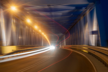 car lights at night in the illuminated tunnel