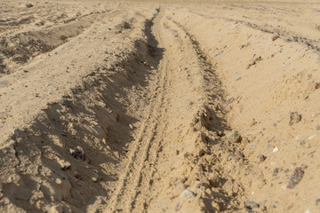 Close-up shots of tire tracks on loose fine beach sand