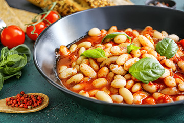 Tasty beans with tomato sauce in bowl on table