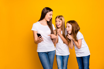 Photo of three funny ladies holding telephone laughing over humor video wear casual clothes isolated yellow background