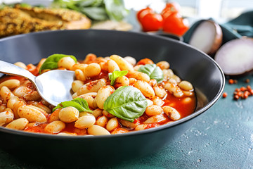 Tasty beans with tomato sauce in bowl on table