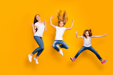 Fototapeta na wymiar Full length photo of three funny ladies jumping high wear casual clothes isolated yellow background