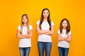 Photo of three sister ladies attentively listening not smiling wear casual white t-shirts isolated yellow background