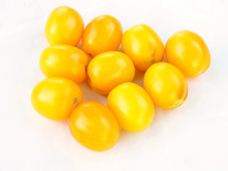 Small identical yellow tomatoes suitable for preservation on a white background