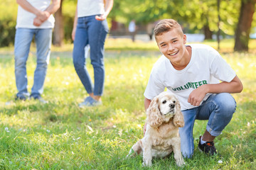 Teenage volunteer with cute dog outdoors