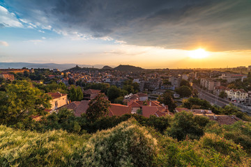 Fototapeta na wymiar Summer sunset cityscape from Nebet tepe Hill in Plovdiv city, Bulgaria. Panoramic view. Ancient Plovdiv is UNESCO's World Heritage.