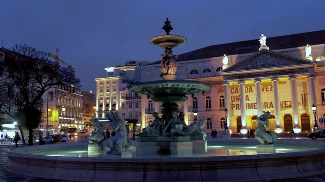 Fountain with National Theatre in Rossio Square in Lisbon, Portugal at night