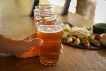 Man drinking fresh beer in pub, closeup
