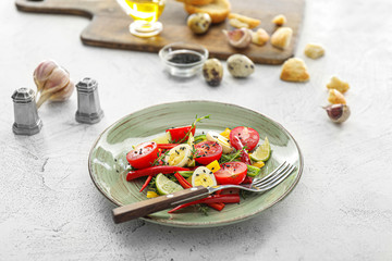 Plate of tasty fresh salad with quail eggs on table