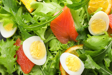 Tasty fresh salad with quail eggs and fish, closeup