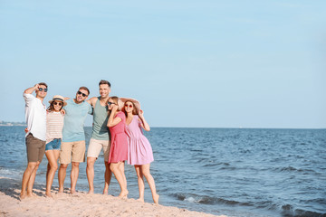 Happy friends on sea beach at resort